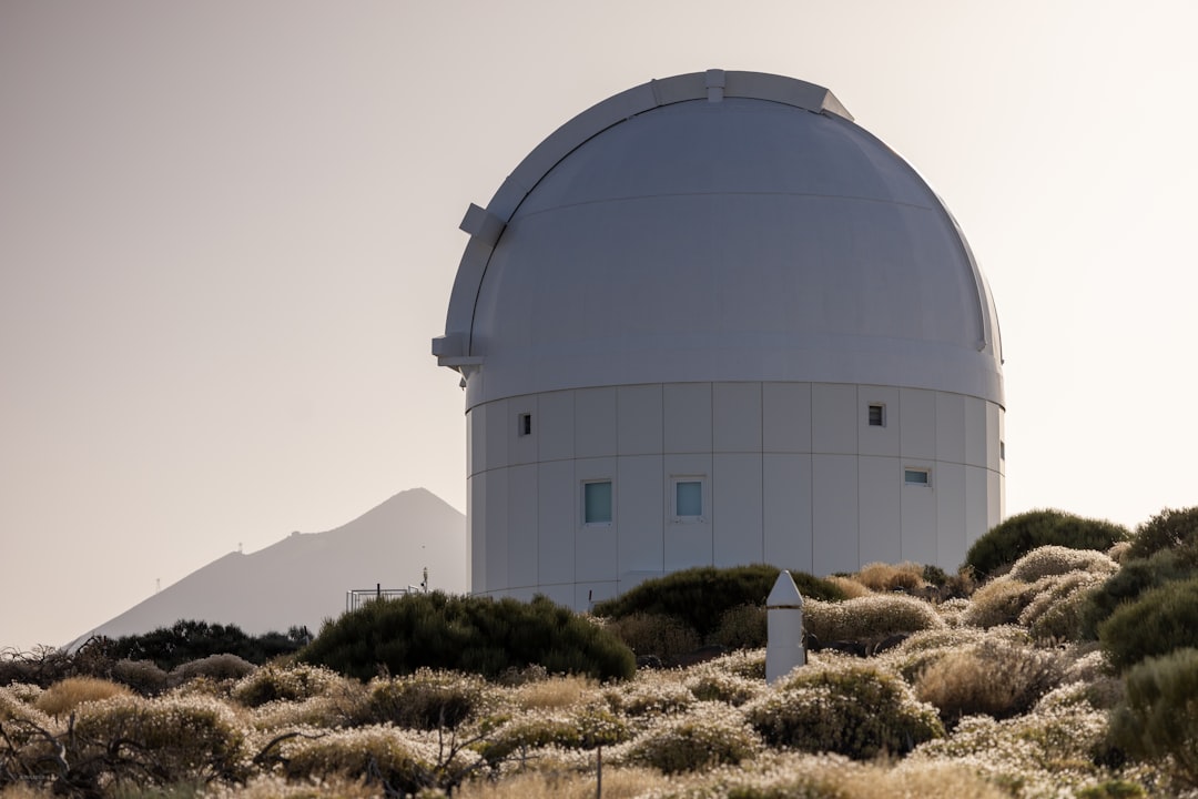 Telescopio em observatorio no alto de uma montanha sob ceu estrelado
