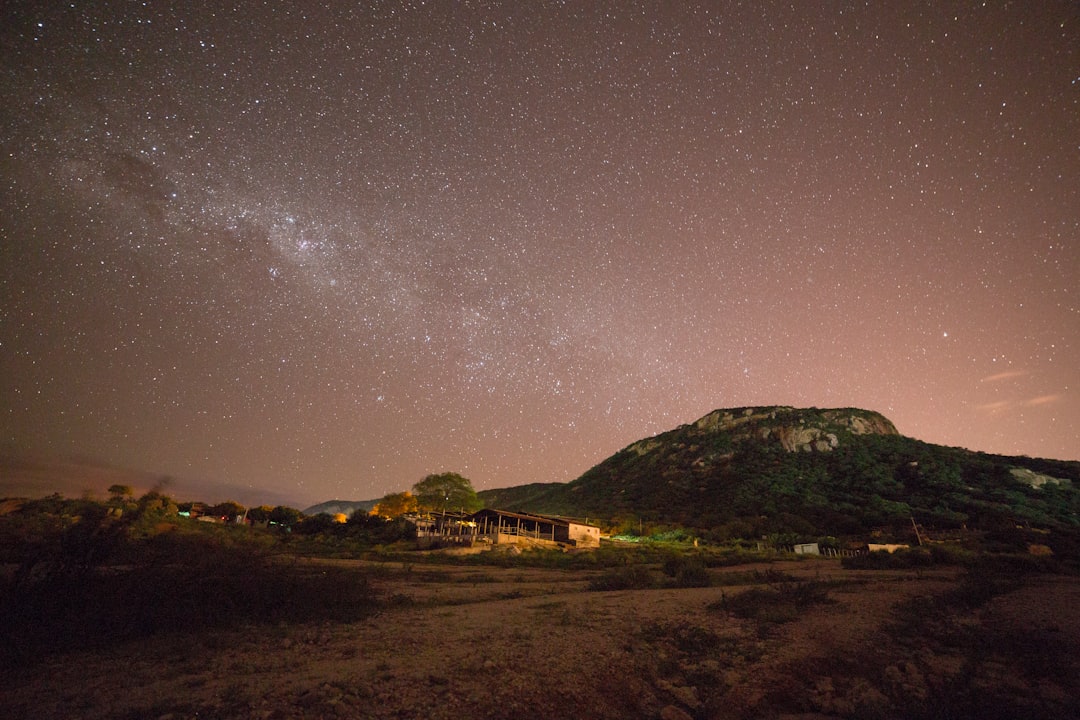 Via Láctea fotografada do interior do Brasil com campo verde em primeiro plano