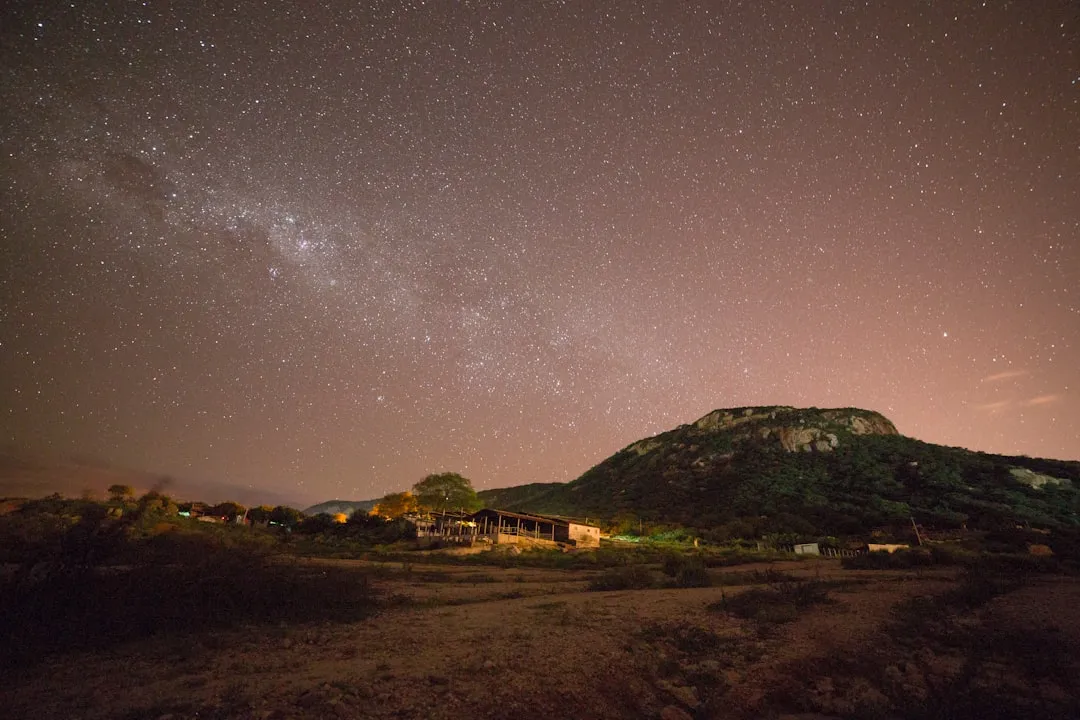 Via Láctea fotografada do interior do Brasil com campo verde em primeiro plano
