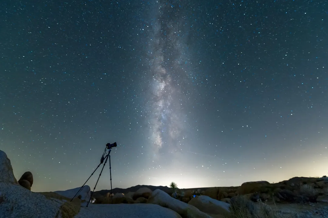 Astronomo amador observando ceu noturno com telescopio em local escuro no Brasil