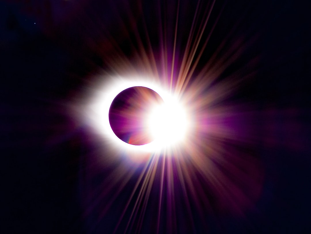 Corona solar brilhante visivel durante eclipse total com prominencias solares rosadas