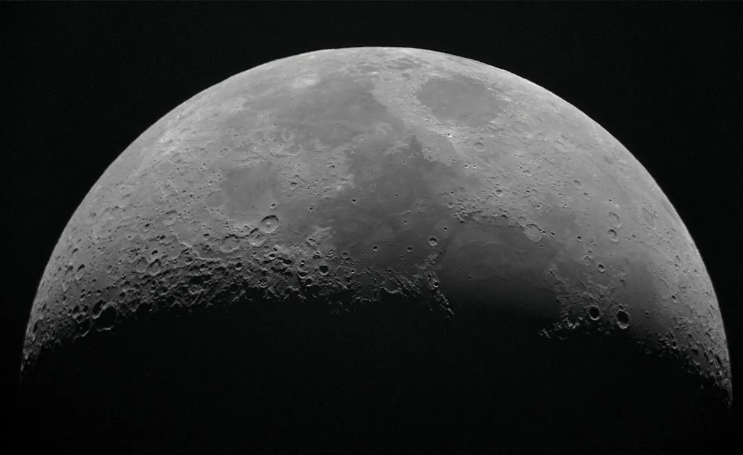 Lua crescente com detalhes de crateras em fotografia com telescopio
